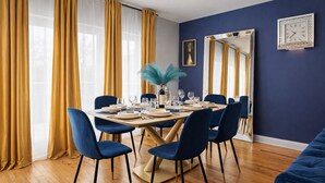 A dining room with a table set for six, blue chairs, a mirror, and a clock on the wall. - Luxe Duplex - Private Gym -Huge Backyard -Arcade- King Beds - Garage-EV Charger (Chicago)