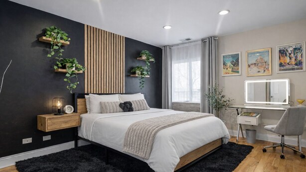 A modern bedroom with a bed, bedside table, and a desk with a chair. - Luxe Duplex - Private Gym -Huge Backyard -Arcade- King Beds - Garage-EV Charger (Chicago)
