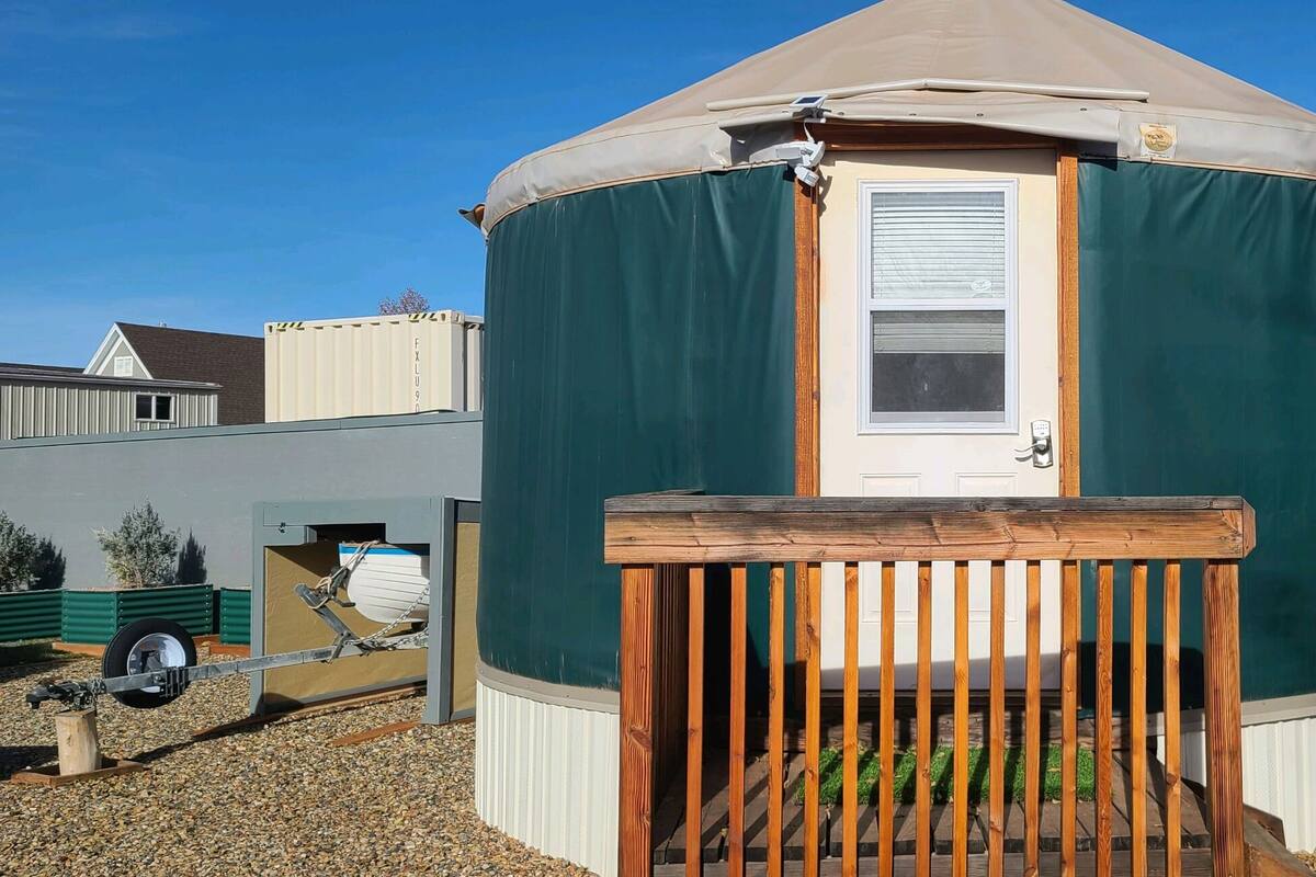 A circular yurt with a door and a small porch.