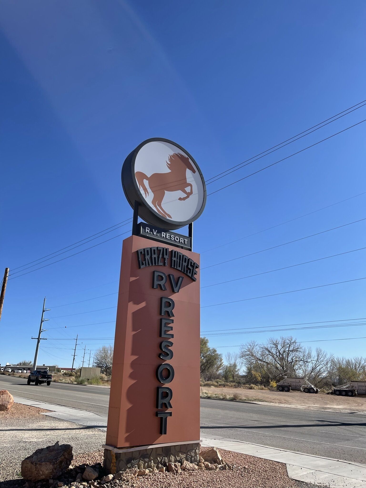 A sign for Crazy Horse RV Resort with a horse logo and text indicating it is an RV resort.