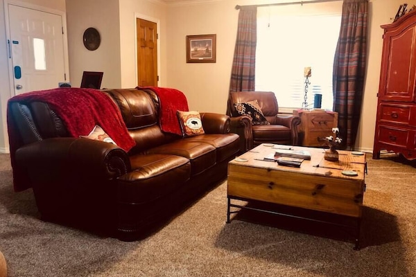 Living area with leather couch and recliners.