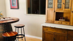 A kitchen with wooden cabinets, a window, and a bar stool.