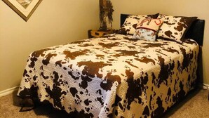 A bedroom with a bed, a nightstand, a wall-mounted picture, and a ceiling fan. - MJ’S BUNKHOUSE #3-2 BLOCKS TO DOWNTOWN (Pawhuska)