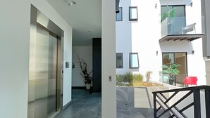 Eine moderne Wohnung mit minimalistischem Design, ausgestattet mit einem geräumigen Wohnbereich, einem Balkon mit Blick und einem aufgeräumten, klaren Interieur.