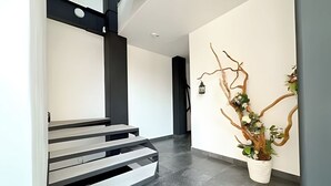 Ein modernes Interieur mit Treppe, minimalistischer Wandgestaltung und einer Zierpflanze.