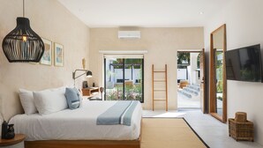 A modern bedroom with a large bed, a TV, and a view of the outdoors. - Illa Cozumel (Cozumel)