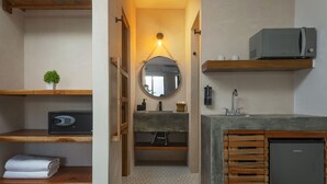 A bathroom with a wooden vanity, a sink, a mirror, a towel rack, and a microwave above the counter. - Illa Cozumel (Cozumel)
