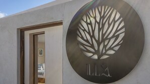 A modern building entrance with a circular logo featuring a tree design and the letters "LLA". - Illa Cozumel (Cozumel)