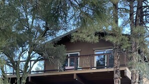 A two-story building with a covered porch and a staircase leading to a balcony.