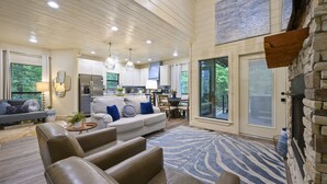 A spacious living room with a large sofa, leather chairs, and a patterned rug. - Pet-Friendly Cabin 5 minutes from town with stunning decor and views! (Broken Bow)