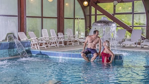 A man and a woman in a swimming pool with lounge chairs and a water feature. - Club Tihany Resort (Tihany)