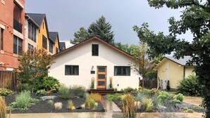 A two-story house with a white exterior and a brown door. It has a number '322' on the front wall. - Vibrant Downtown Bungalow – Walk Everywhere! (Fort Collins)