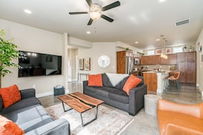 Relax in this stylish living space with a sofa, coffee table, and round mirror.