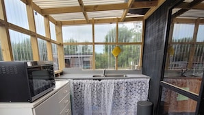 Cocina compacta con microondas, lavabo y armarios.