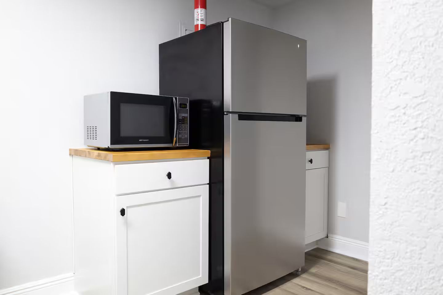 A kitchen with a microwave and a refrigerator.