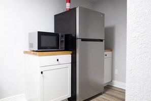 A kitchen with a microwave and a refrigerator.