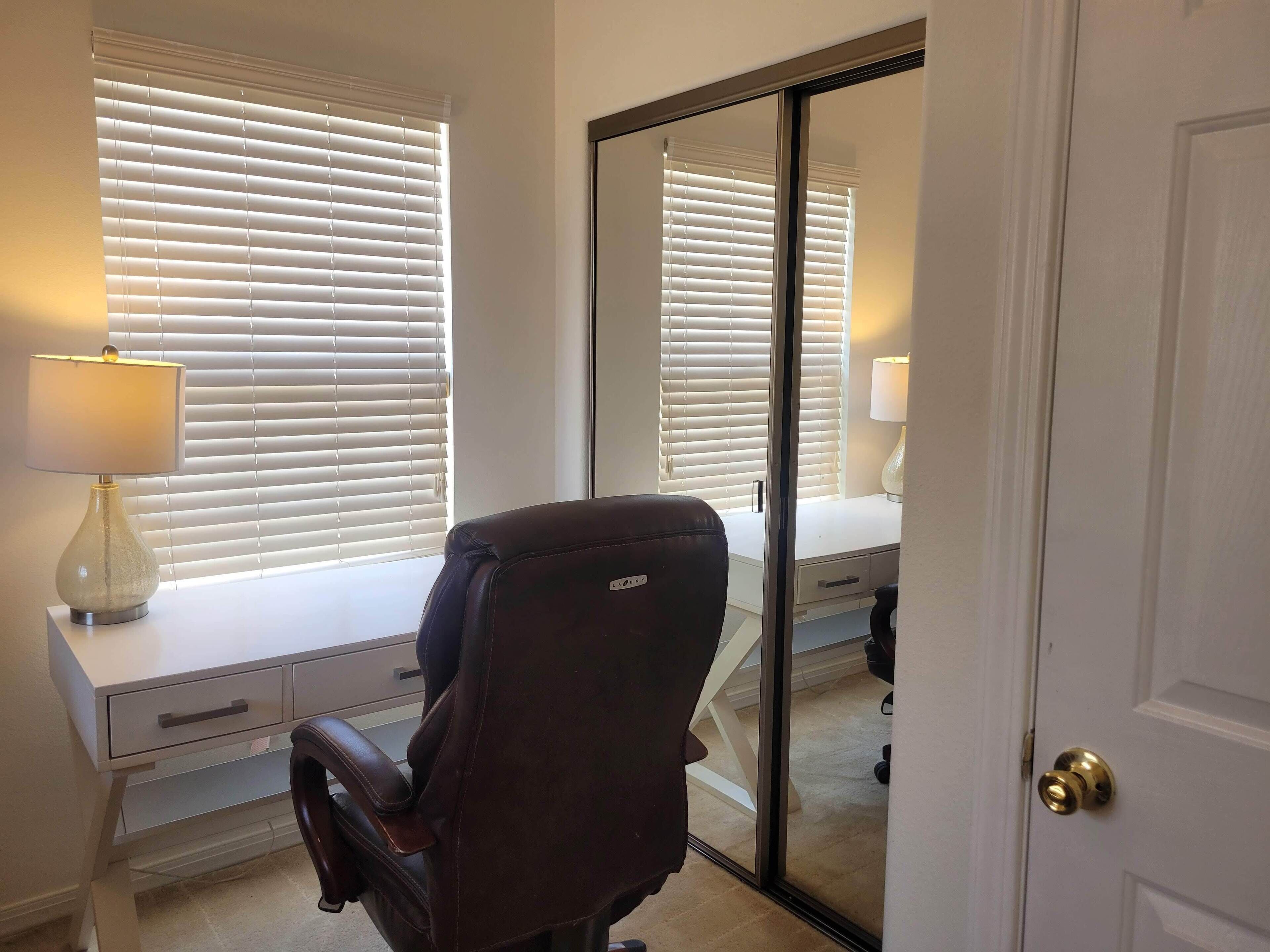 Una habitación con escritorio, silla y puerta corrediza.