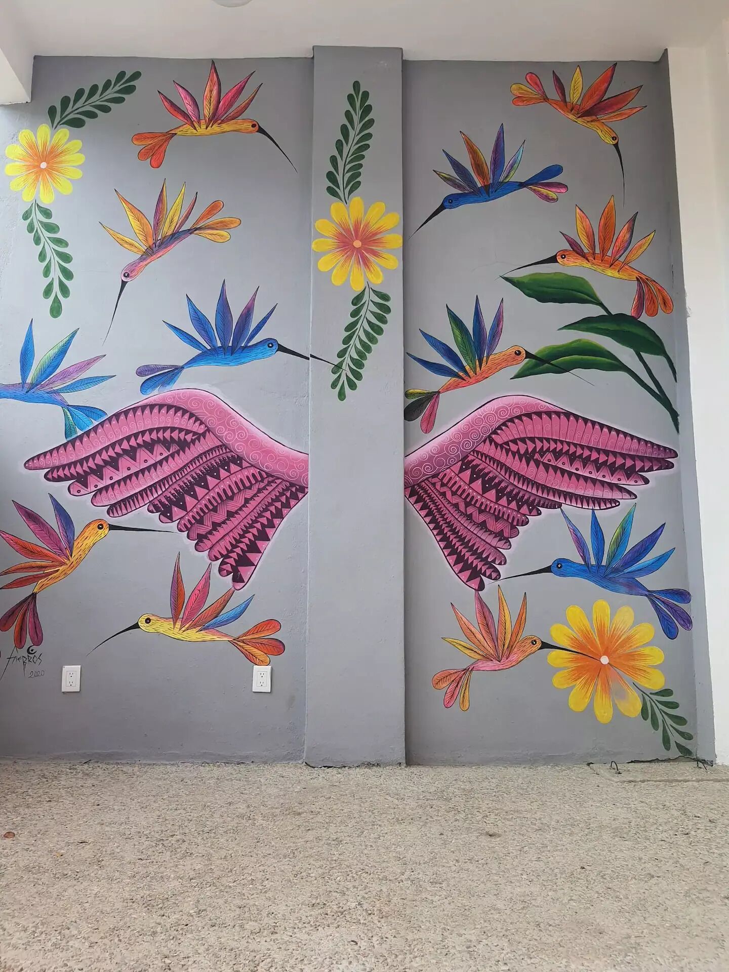 Two large wall murals with vibrant bird and flower paintings.