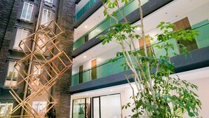 A modern building with multiple floors, large windows, and indoor plants. - The Star Hill  (Chiang Mai)