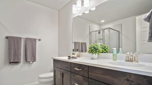 Bathtub, hair dryer, towels, shampoo
