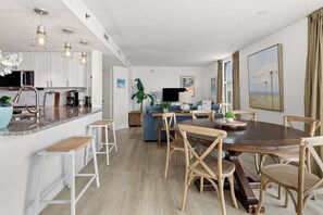 A modern kitchen with white cabinets, a granite countertop, and pendant lighting. - Spacious, luxury North Myrtle Beach oceanfront condo with amenities galore (North Myrtle Beach)