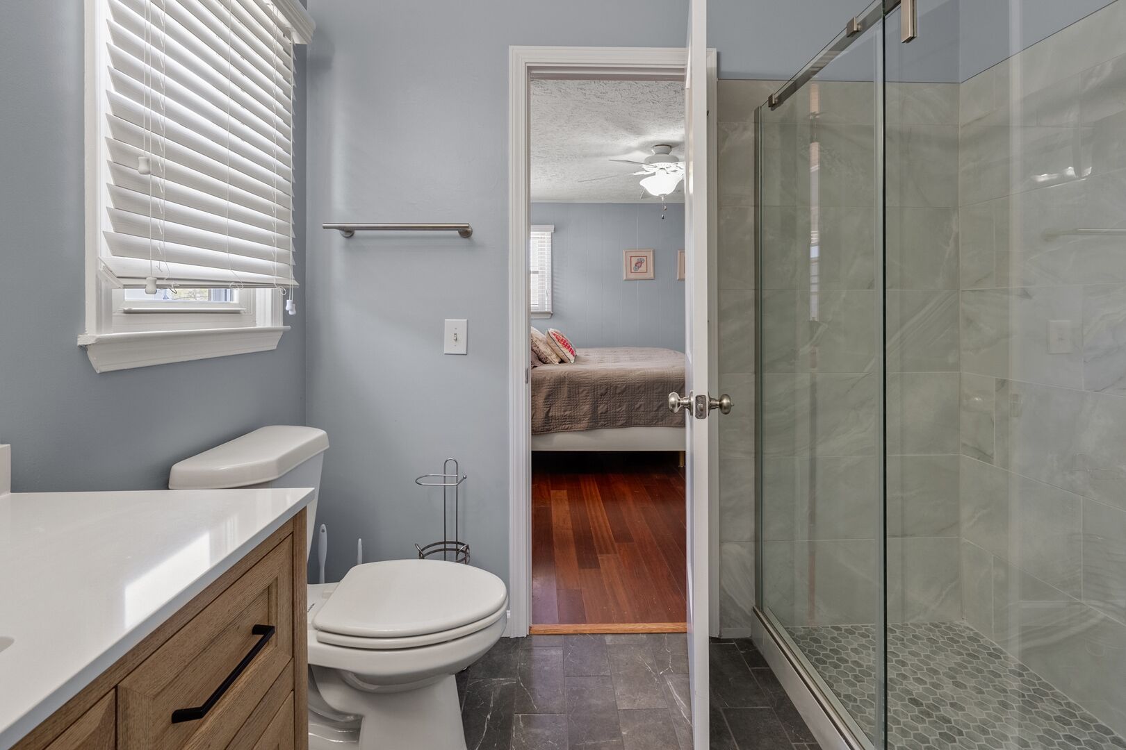 A bathroom with a toilet, sink, and shower.