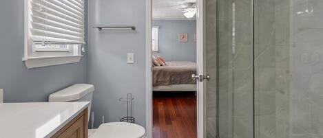 A bathroom with a toilet, sink, and shower.