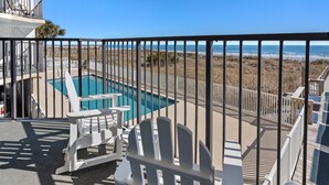 Área da piscina com vista para a praia e oceano.