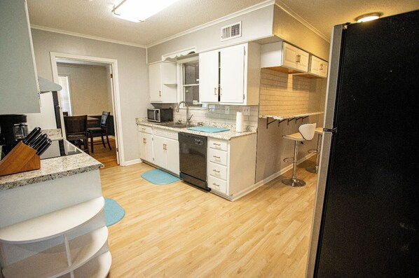 Compact kitchen with microwave, sink, and refrigerator, perfect for preparing meals.