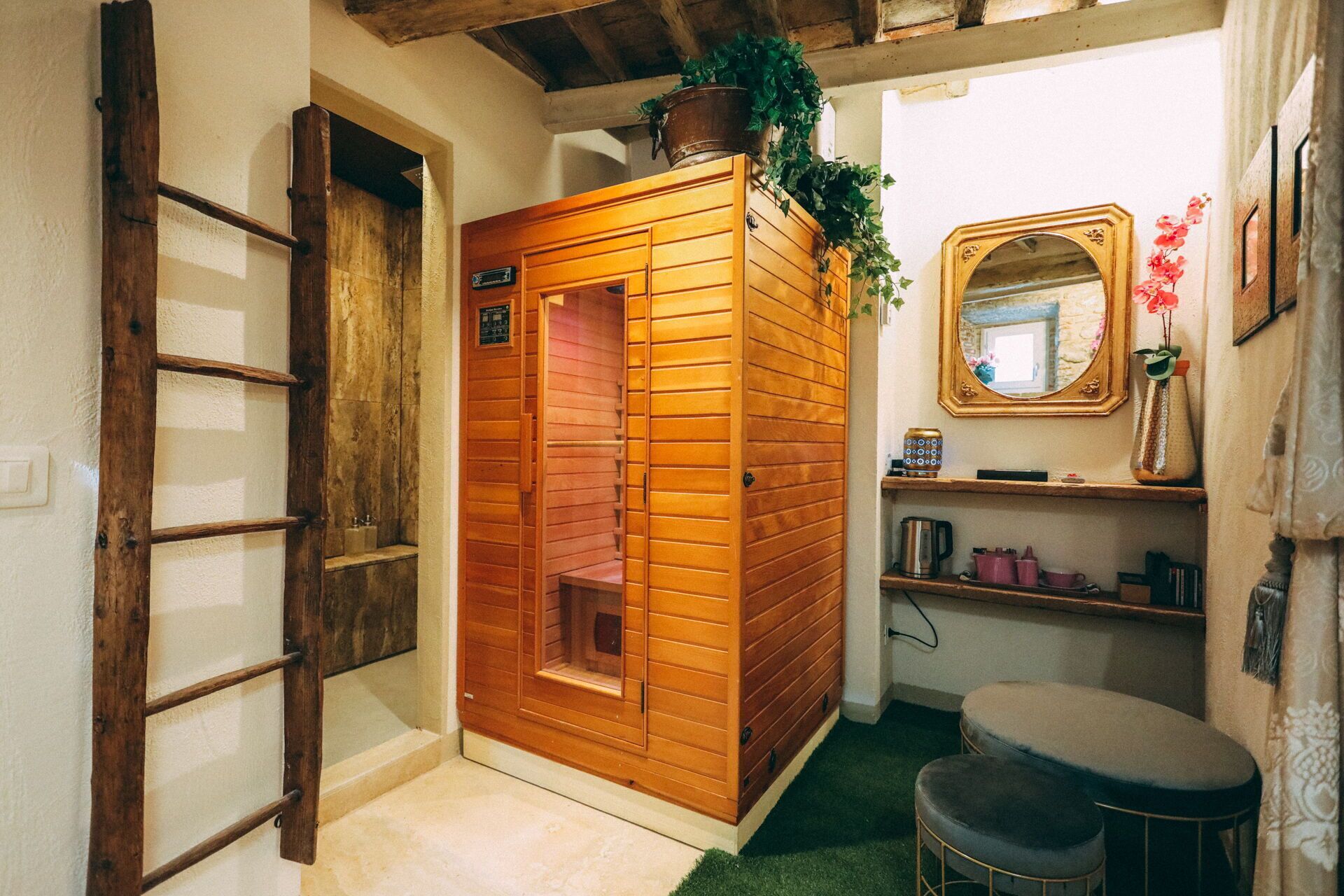 A sauna with wooden panels, a mirror, a shelf with items, and a small seating area.