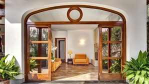 A spacious living area with a wooden archway, a sofa, and potted plants. - Tulipano - A Charming and Peaceful Hillside Villa With Lovely Views (Massa Lubrense)