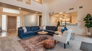 A spacious living room with a large sectional sofa, a round coffee table, and a patterned rug. - Casa Buenaluxurious Retreat w/2 Masters & Views! (Phoenix)