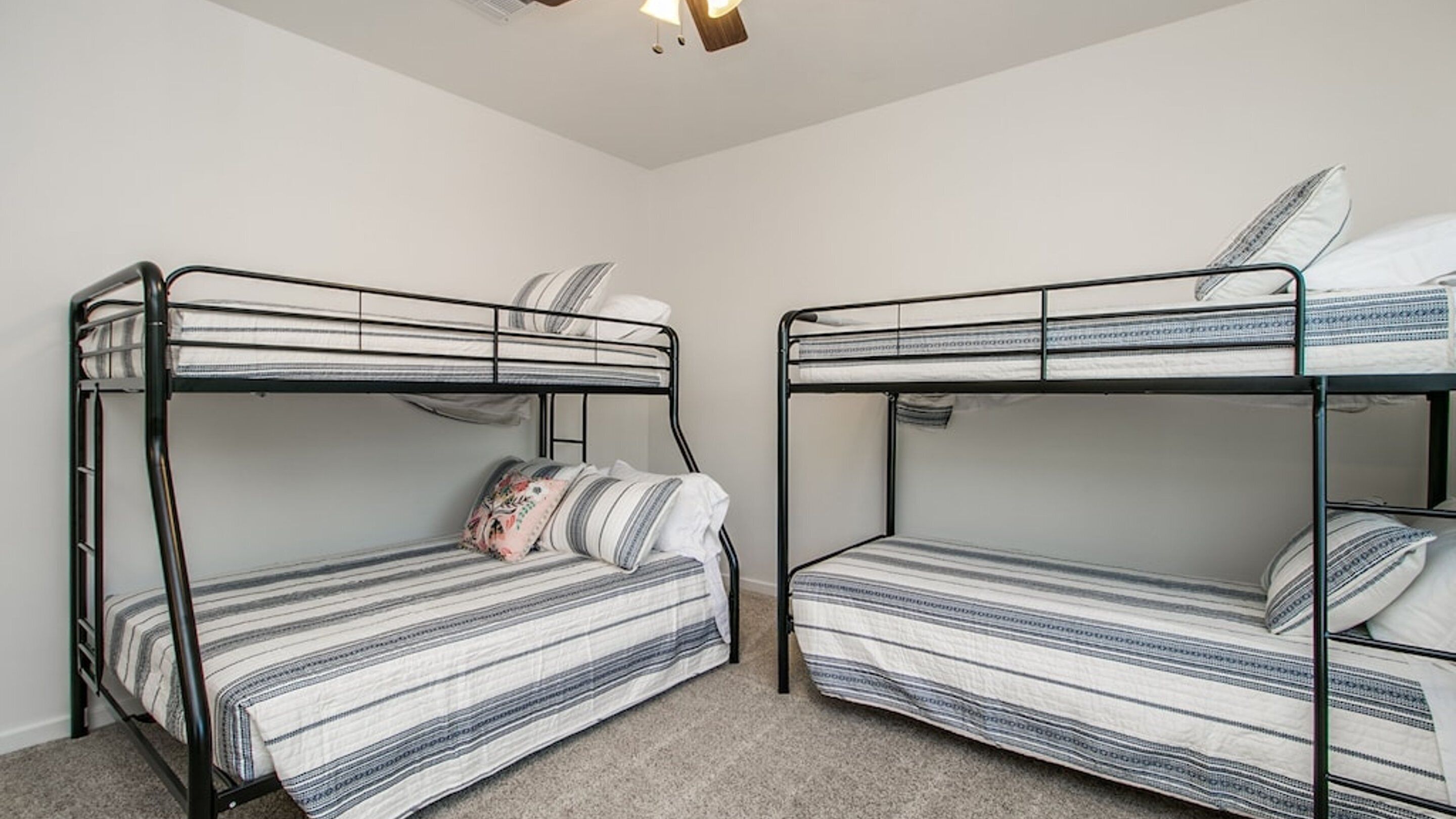 Una habitación con dos literas, cada una con un colchón y almohadas a rayas.