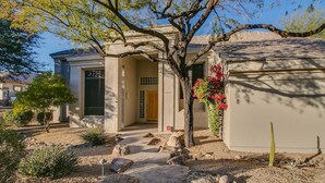 A house with a front door, a garage, and a small garden with rocks and plants. - Casa Buenaluxurious Retreat w/2 Masters & Views! (Phoenix)