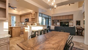 A spacious kitchen with wooden cabinets, a large island, and a dining area with a wooden table. - Casa Buenaluxurious Retreat w/2 Masters & Views! (Phoenix)