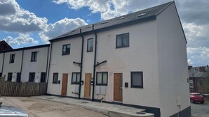 A row of modern, two-story townhouses with a flat roof and a white facade. - Impeccable 1-bed Apartment in Chesterfield (Chesterfield)