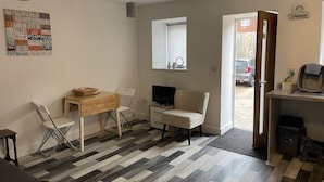 A compact living space with a dining area, a TV, and a view of the street. - Impeccable 1-bed Apartment in Chesterfield (Chesterfield)