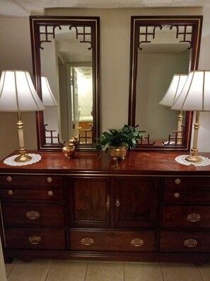 A wooden dresser with two mirrors, a potted plant, and two lamps. - Comfortable quiet living space private clean (Stonecrest)