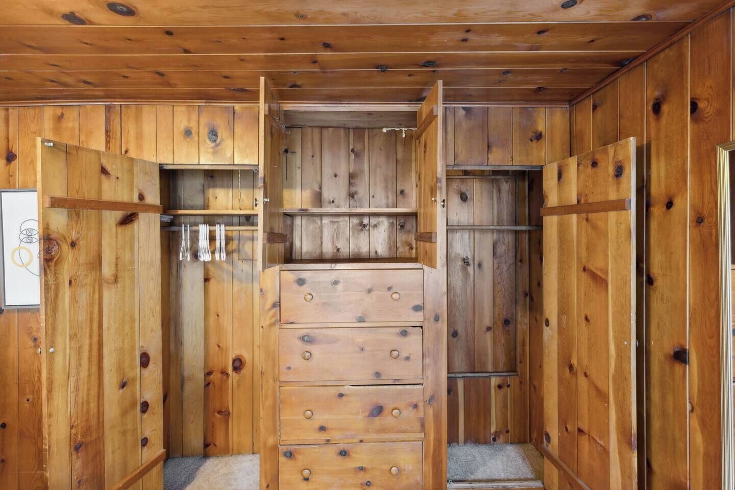 Un intérieur en bois avec un meuble central doté de tiroirs et d’une étagère suspendue.