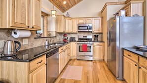 A modern kitchen with wooden cabinets, stainless steel appliances, and a wooden ceiling. - 22STR-00367 Fairplay Cabin ~ 6 Mi to Downtown! (Fairplay)