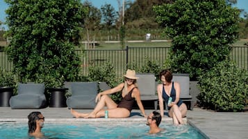 Una piscina al aire libre, tumbonas