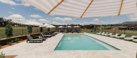 Una piscina al aire libre, tumbonas