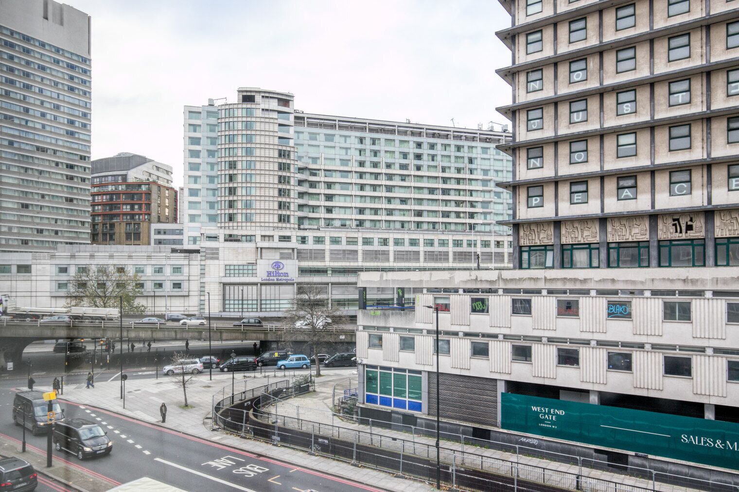 Een hotel met een modern design, met een opvallend Hilton logo en een bord voor West End Gate.