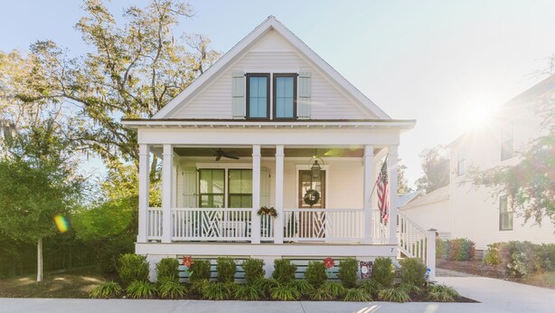 A white two-story house with a front porch, a small garden, and a mailbox. - Old Town Bluffton Beaches and Birdies House (Bluffton)