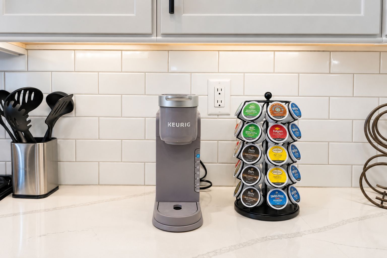 Cozinha equipada com cafeteira Keurig e suporte para cápsulas de café de diversas marcas.