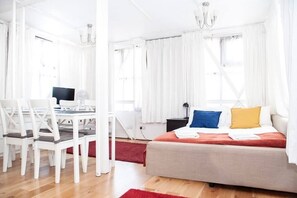 Un dormitorio moderno con cama, escritorio y silla.