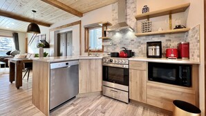Una cocina moderna equipada con lavavajillas, estufa, horno y microondas.