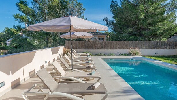 A poolside area with lounge chairs and umbrellas.
