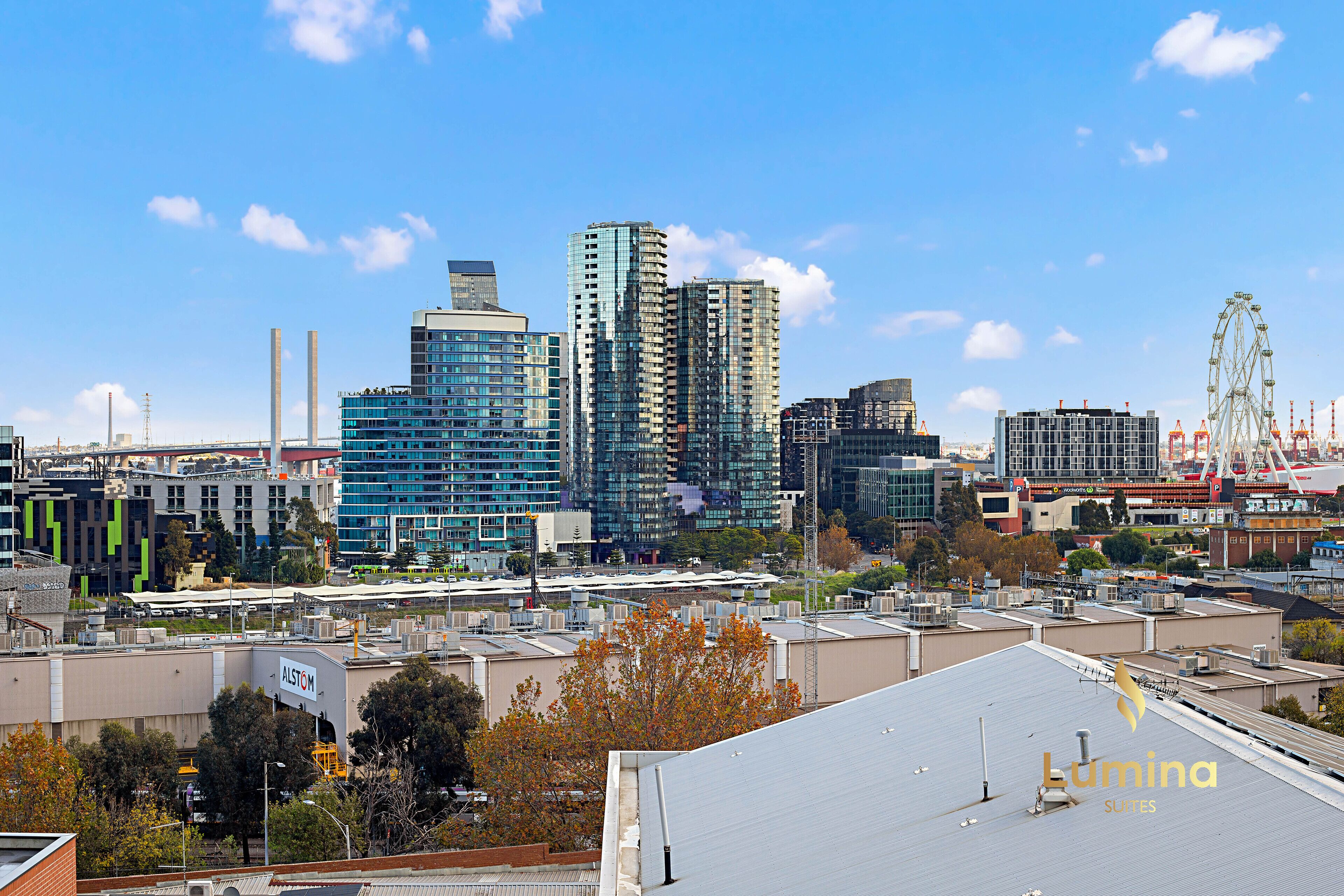 A cityscape with modern high-rise buildings, a Ferris wheel, and a construction site.