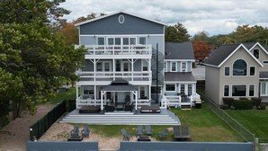 A multi-story house with a balcony, a covered patio, and a front porch. - Penthouse | Historic Oneida Lakefront Condo 5 (Blossvale)